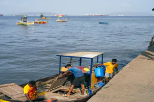 People looking down at the boat after it landed on the shore