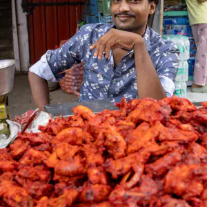 Man selling bright red food