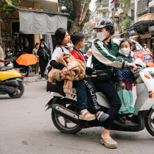 1台のバイクに乗った家族連れ