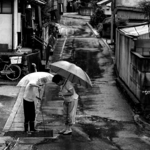Two women standing in rain