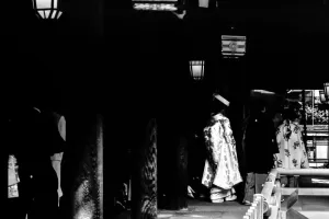 Bride walking the dark cloister in Meiji Jingu