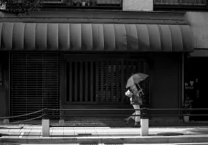 Umbrella walking in front of shop