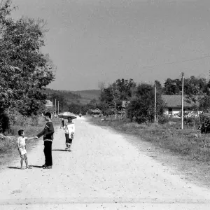 Two boys and one woman on dirt road