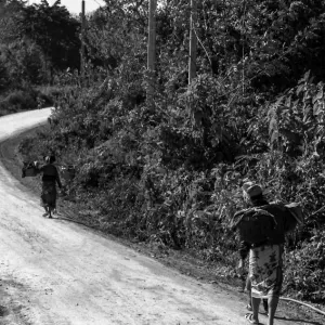 Women walking dirt road with burden