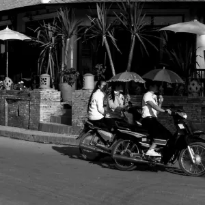 日傘を差しながらバイクに乗る女性