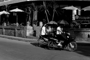 Women putting sunshade up while riding motorbike