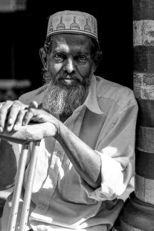 Man with a long beard resting in Jami Ul-Alfar Mosque