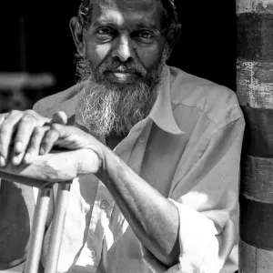 Man with a long beard resting in Jami Ul-Alfar Mosque