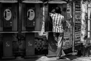 Man calling from telephone booth