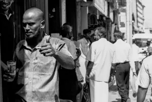 賑わっている道で親指を立てる男