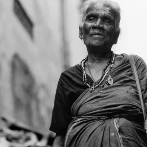 Older woman walking with saree and necklace