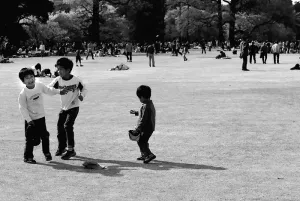 芝生の上で遊ぶ三人の男の子