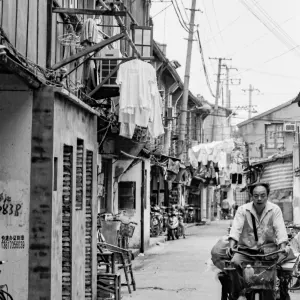 Man pedaling tricycle with luggage carrier