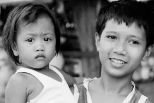Little girl held by elder boy