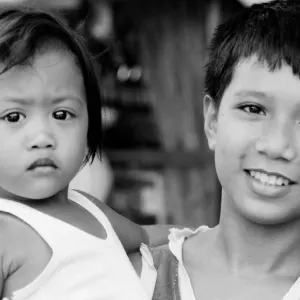 Little girl held by elder boy