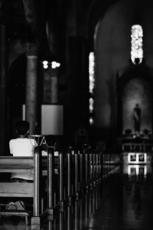 薄暗いマニラ大聖堂で参拝する信者