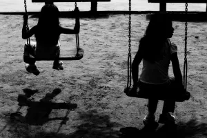 Silhouetted girls playing on swing