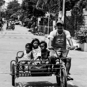 Family on bicycle with sidecar