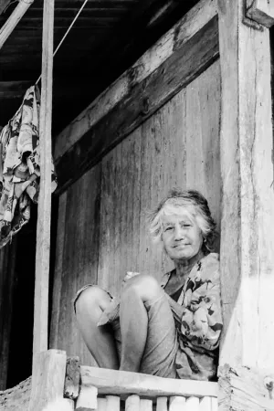 Woman with silver hair sitting under eaves