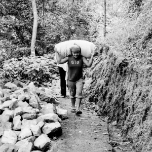 Woman carrying burden on shoulder