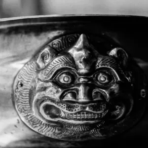 grotesque face sculptured on bowl