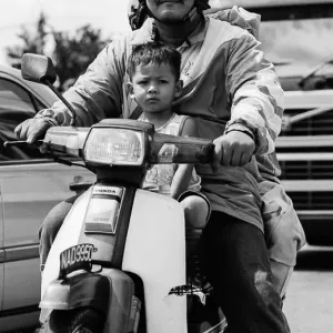 Father and son riding on same motorbike