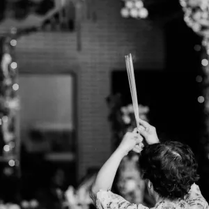 Woman praying with long incense sticks