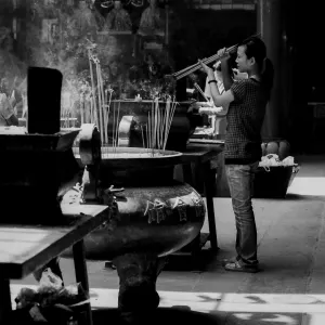 Woman lighting incense sticks on fire