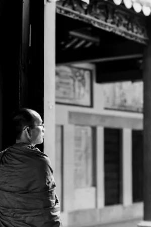 扉のところに佇む袈裟を纏った僧侶