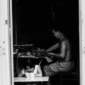 Girl eating and father working