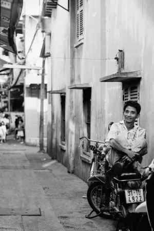 バイクの上で膝を抱えた男