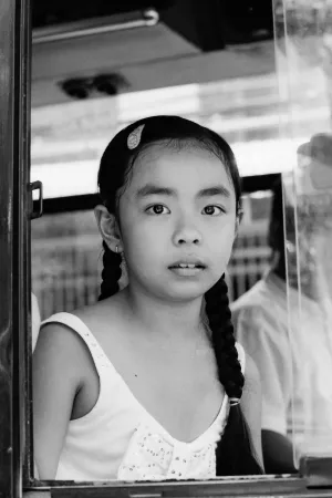 Girl sitting on window seat of a bus