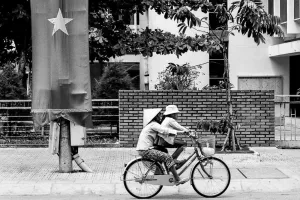 ベトナム国旗の前を通り過ぎる自転車