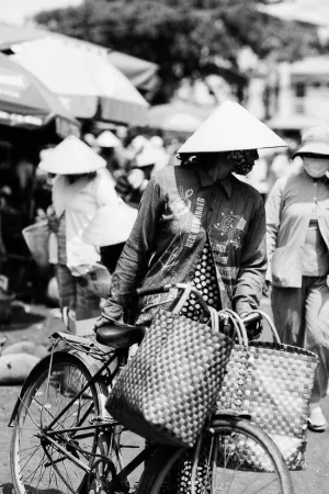 Woman walking bicycle in market