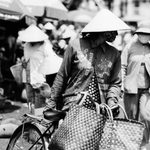 Woman walking bicycle in market
