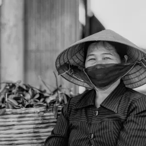 Woman wearing conical hat and black mask
