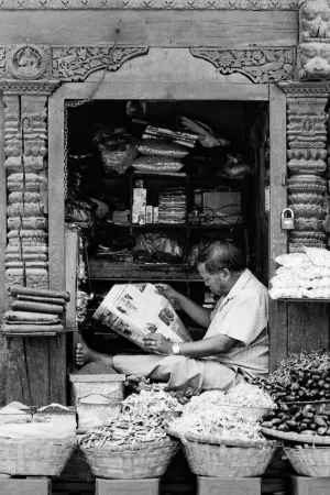 Storekeeper reading newspaper
