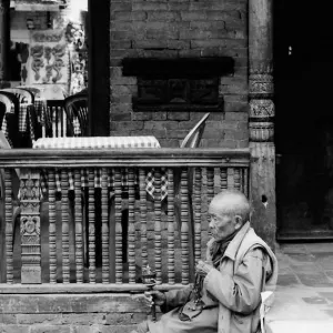 Elderly Tibetan monk with prayer wheel