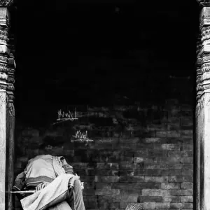 Man sleeping between wooden pillars