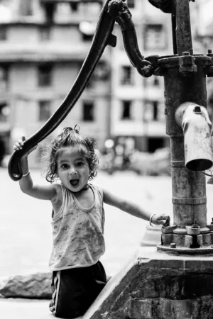 Girl opening mouth wide beside a well