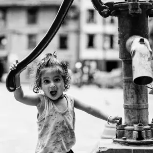 Girl opening mouth wide beside a well