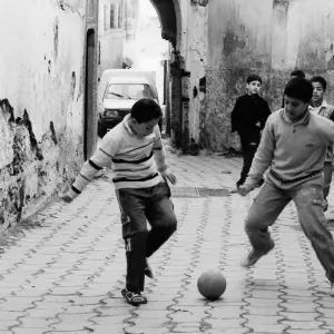 Boys playing football in lane