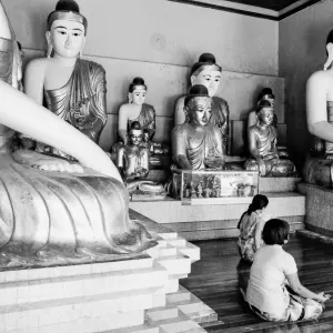 Women surrounded by Buddha statues