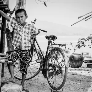 Boy posing in front of a bicycle