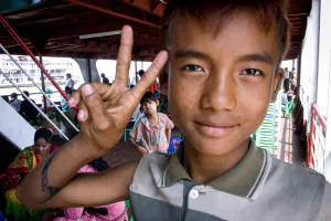 Young vendor boy making a peace sign