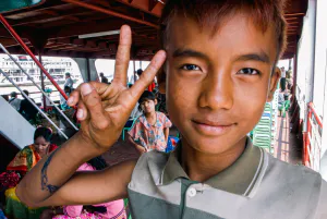 Young vendor boy making a peace sign