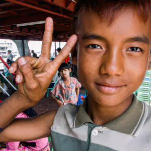 Young vendor boy making a peace sign
