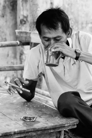Man smoking a cigar and drinking coffee