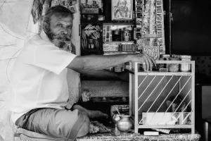 Man sitting cross-legged in a small store