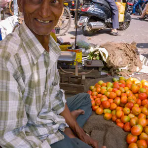 トマトを売るティラカを付けた年配の男